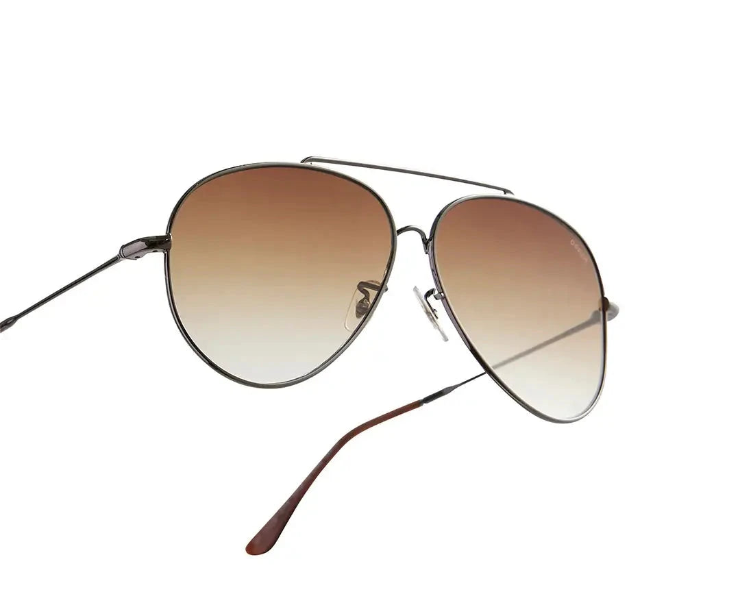 Aviator-style sunglasses with a sleek metal frame and gradient brown lenses. The design features a double bridge and thin arms with brown-tipped earpieces, giving them a classic and timeless look. The lenses transition smoothly from dark to light, adding a stylish flair while providing sun protection.